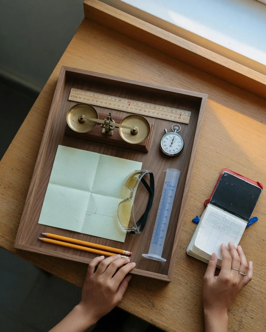A simple measuring kit laid out and ready &mdash; a ruler, a balance, a stopwatch, and a graduated cylinder of plain water.